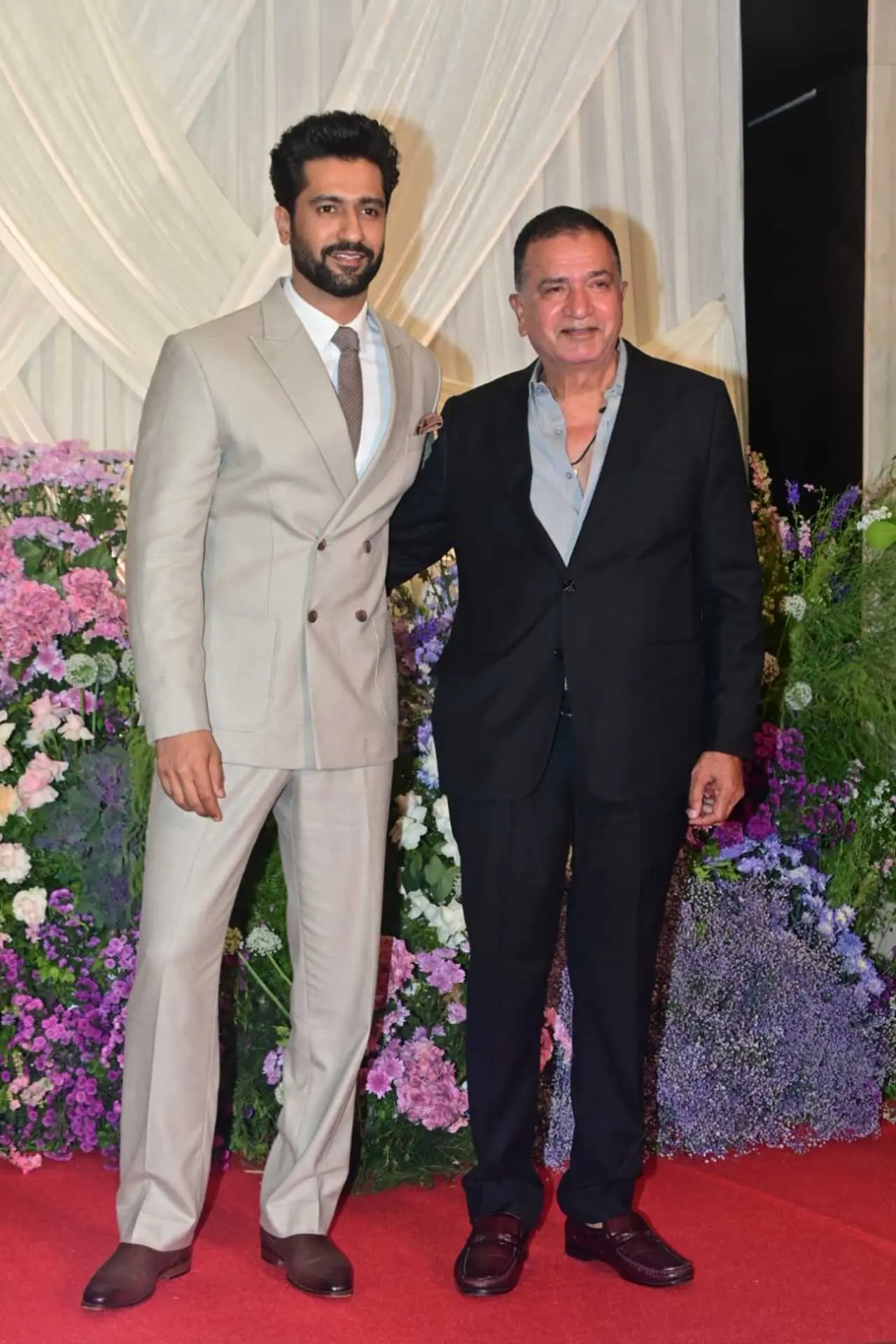 <p><span class="hover:entity-accent entity-underline inline cursor-pointer align-baseline"><span class="whitespace-normal">Vicky Kaushal</span></span> attended <span class="hover:entity-accent entity-underline inline cursor-pointer align-baseline"><span class="whitespace-normal">Sooraj Barjatya</span></span>&rsquo;s daughter&rsquo;s wedding reception with his father <span class="hover:entity-accent entity-underline inline cursor-pointer align-baseline"><span class="whitespace-normal">Sham Kaushal</span></span>. Vicky looked sharp in a grey pantsuit paired with a crisp white shirt, keeping his look sleek and sophisticated.&nbsp;</p>